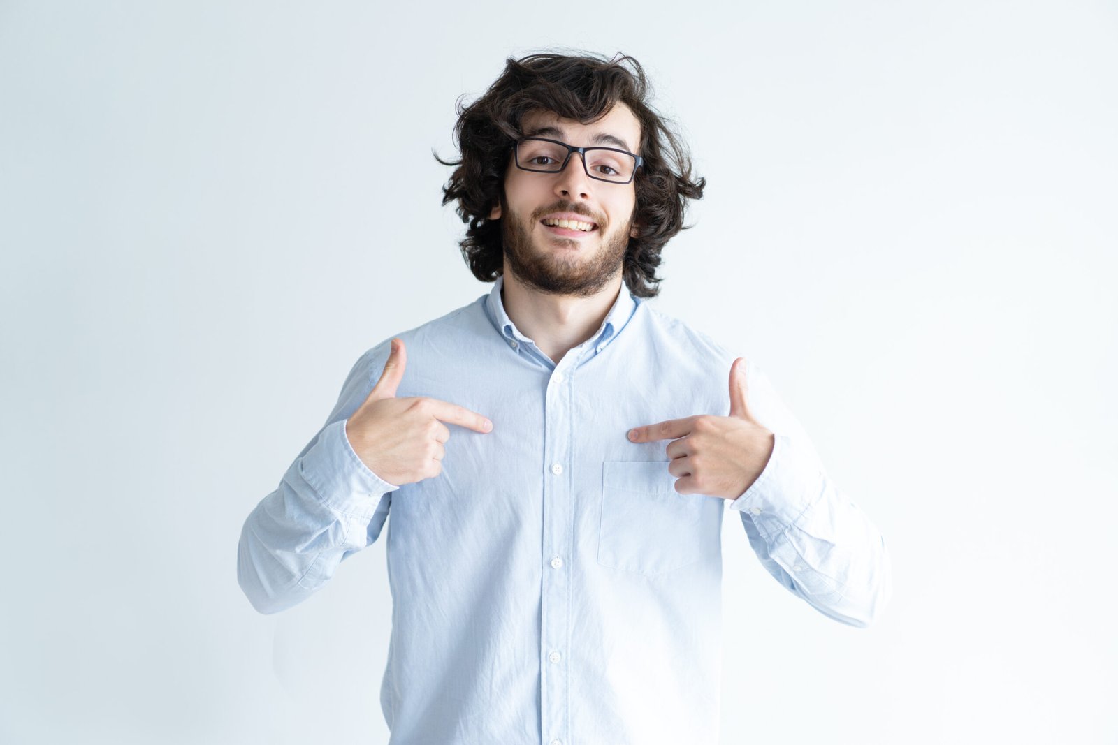 Confident black-haired young man pointing at himself Confident black-haired young man pointing at himself and looking at camera. Confident attractive guy. Self-reliance concept. Isolated front view on white background.